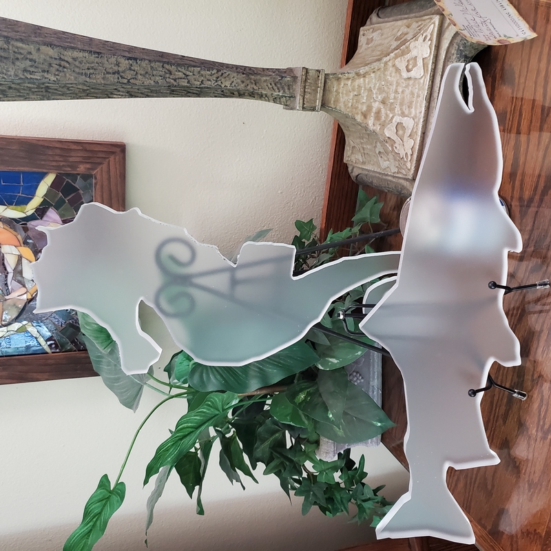 cnc router cut acrylic salmon and seahorse shapes on a shelf